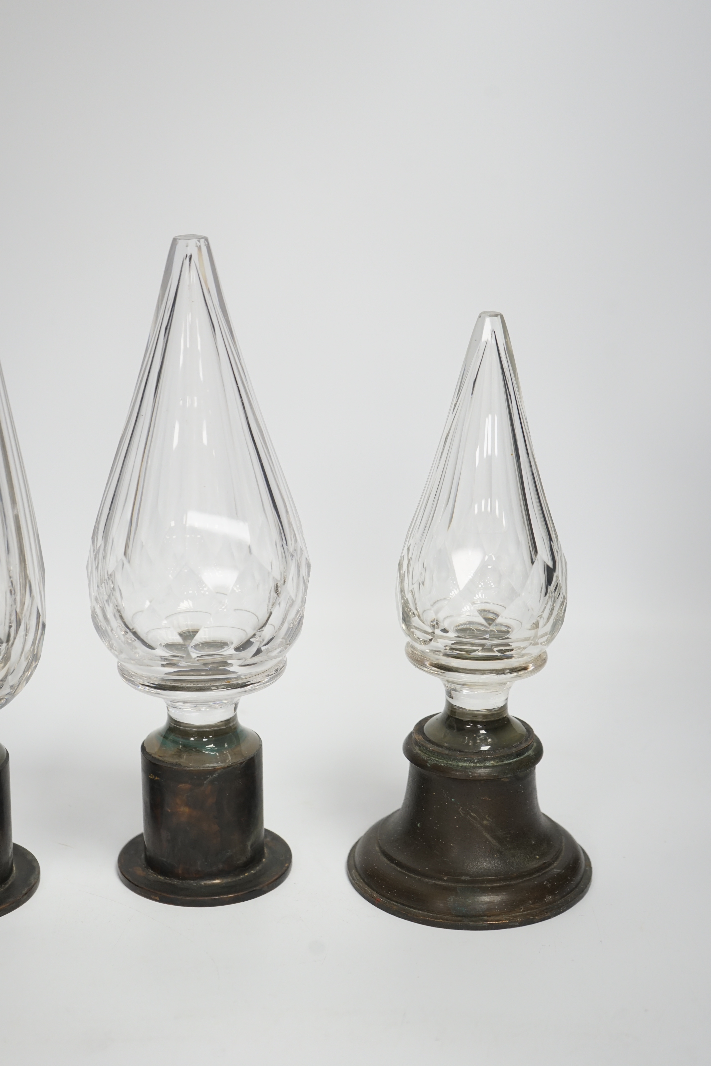 Three Large cut glass stoppers mounted on brass bases, highest 32.5cm